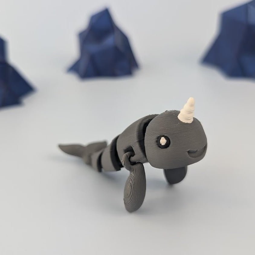 Narwhal articulated figure posed mid-swim, flexible body extended
