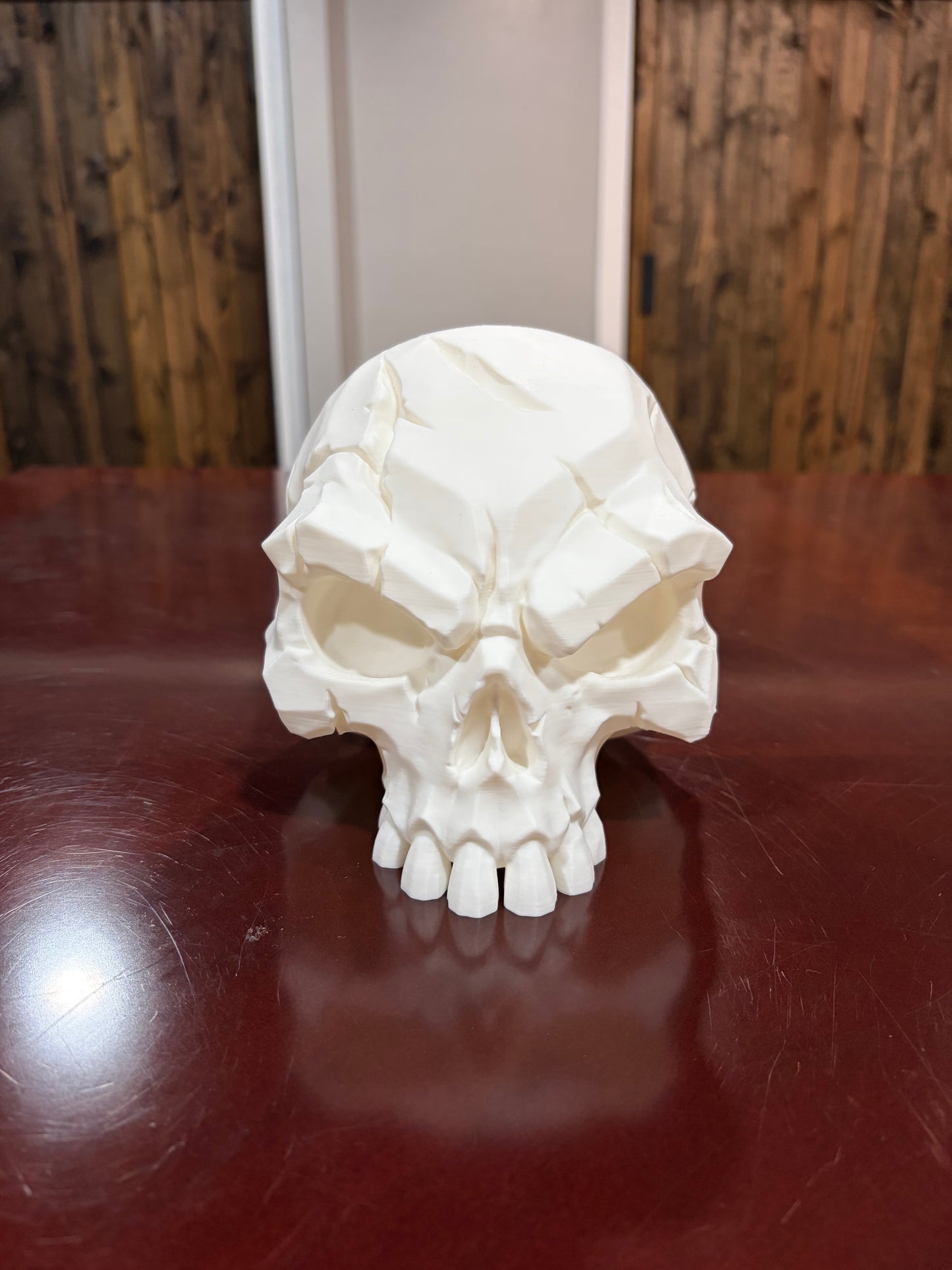 White 3D printed battle scar skull with sculpted scar details, front view
