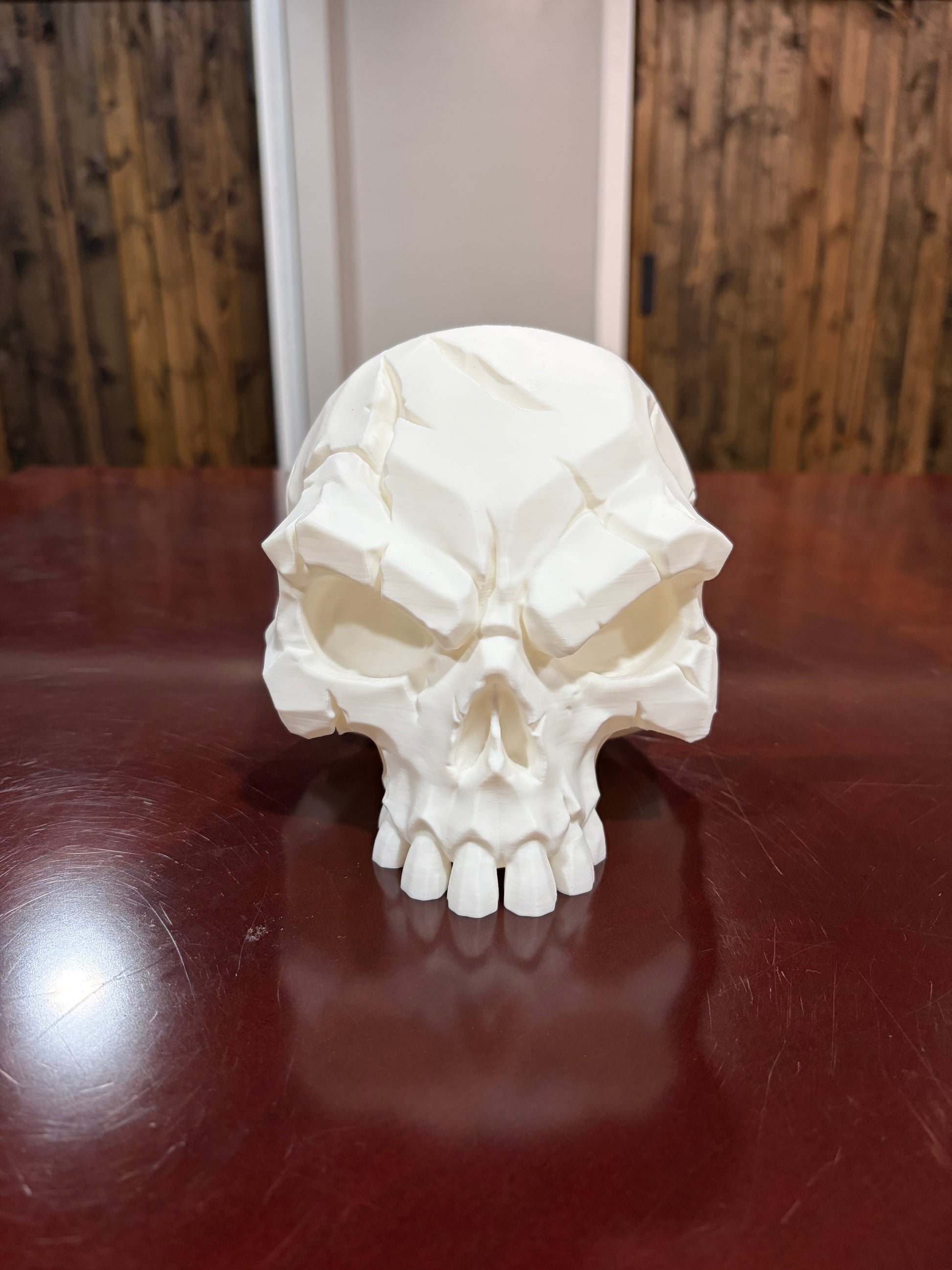 White 3D printed battle scar skull with sculpted scar details, front view
