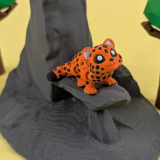 Articulated 3D printed Leopard figure posed on a stone, spotted body
Flexi Leopard articulated keychain shown from the front
Side view of the articulated Leopard keychain showing its bending joints
