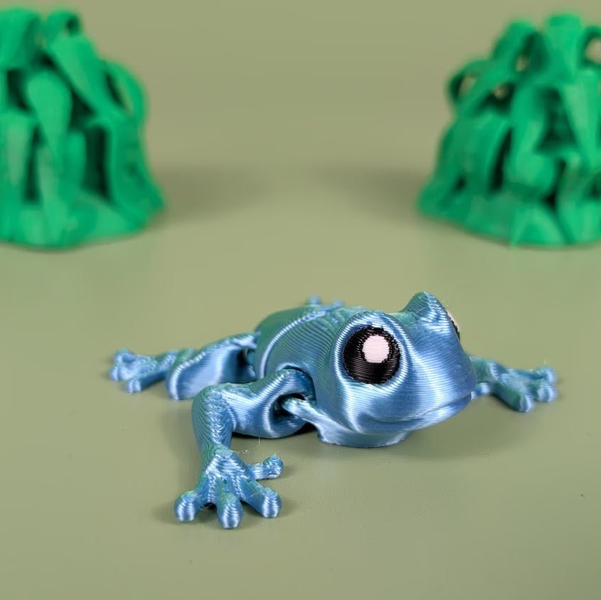 Articulated 3D printed Poison Dart Frog with bold rainforest coloring, top view
Poison Dart Frog figure posed to show its bending, flexible joints
